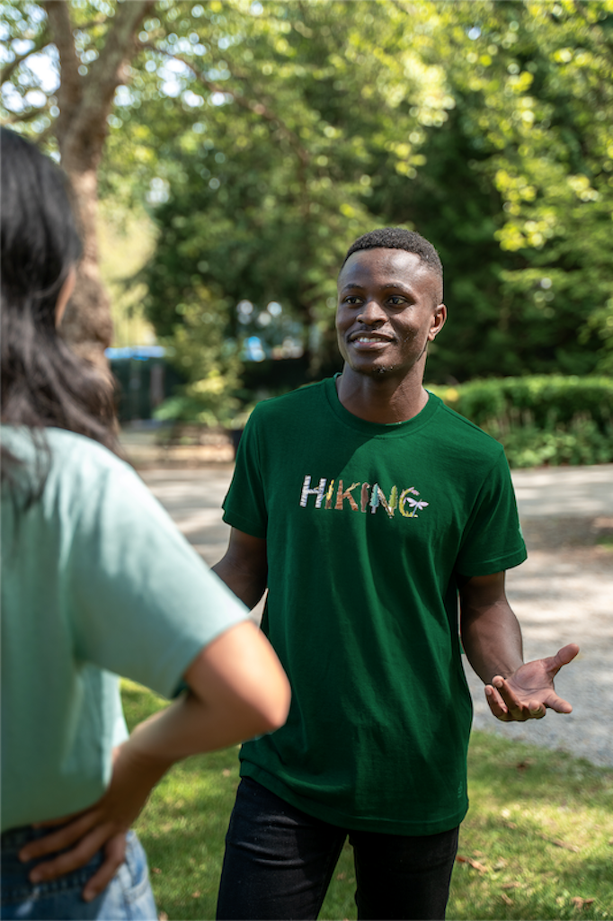 Model wearing the Adventure in Letters Tee by VELU for men, a sustainable organic cotton t-shirt designed for outdoor enthusiasts and eco-conscious shoppers.
