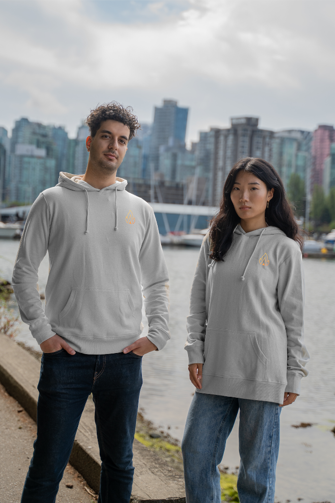 Models wearing the Vancouver Landmarks Hoodie by VELU, a sustainable and eco-friendly unisex hoodie, with a Vancouver cityscape backdrop.